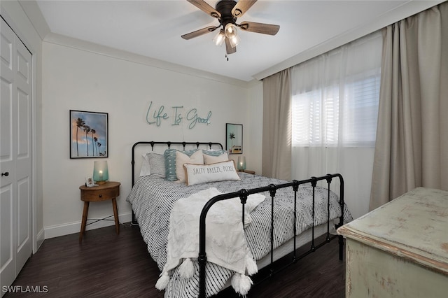 bedroom featuring dark wood-type flooring, a closet, and ceiling fan