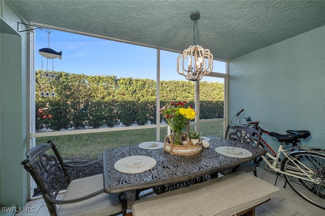 sunroom featuring a chandelier