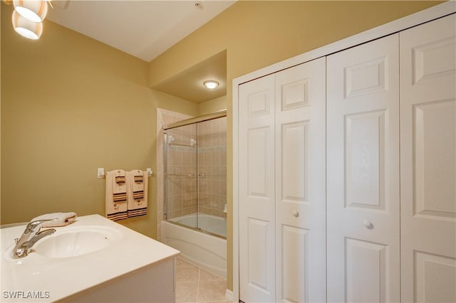 bathroom featuring vanity, tile patterned flooring, and combined bath / shower with glass door