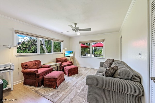 living room featuring crown molding, plenty of natural light, ceiling fan, and light wood-type flooring