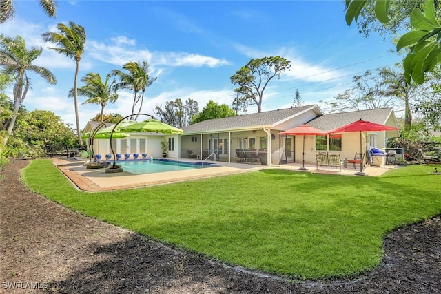 rear view of property featuring a yard and a patio area