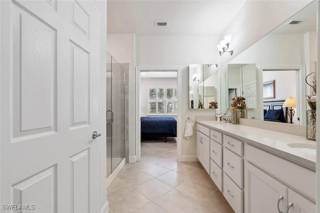 bathroom with tile patterned flooring, vanity, and walk in shower