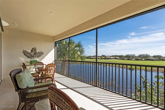 sunroom featuring a water view and a healthy amount of sunlight