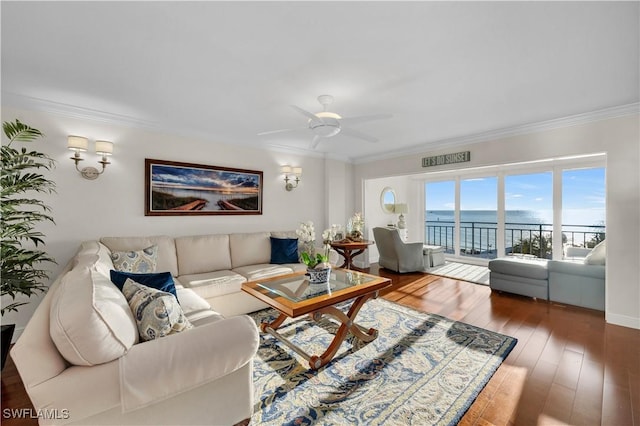 living room with ornamental molding, a water view, hardwood / wood-style floors, and ceiling fan