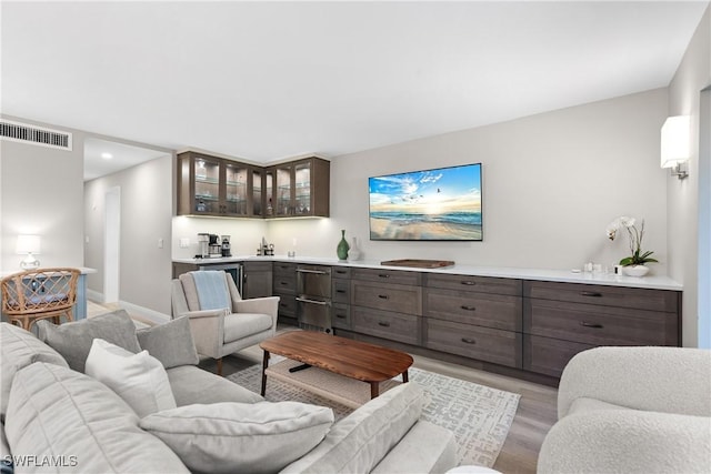 living room featuring bar and light hardwood / wood-style floors