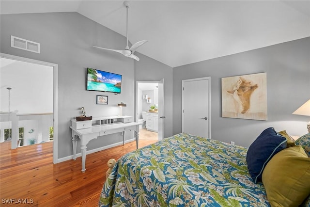 bedroom with lofted ceiling, connected bathroom, hardwood / wood-style flooring, and ceiling fan