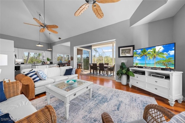 living room featuring a healthy amount of sunlight, hardwood / wood-style floors, high vaulted ceiling, and ceiling fan