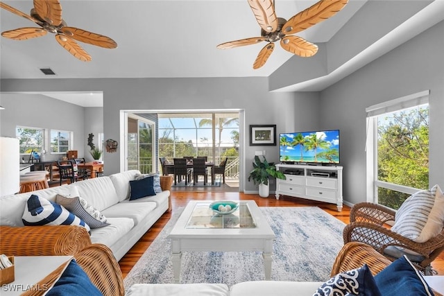 living room with wood-type flooring, vaulted ceiling, and ceiling fan