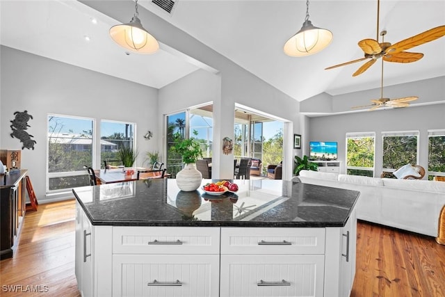 kitchen with a kitchen island, white cabinets, and decorative light fixtures