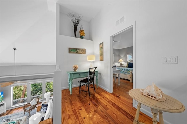 corridor with a high ceiling and hardwood / wood-style floors