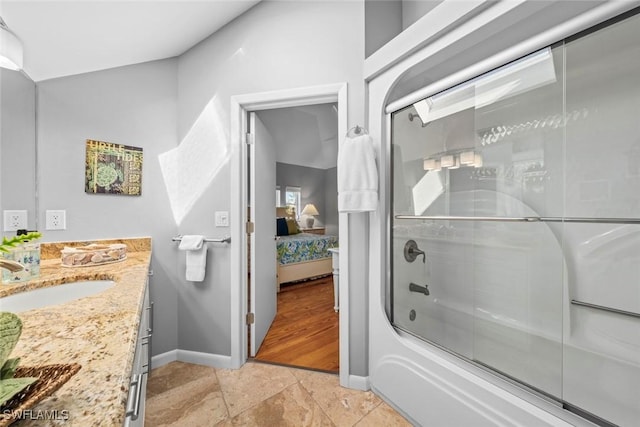 bathroom with vanity and shower / bath combination with glass door