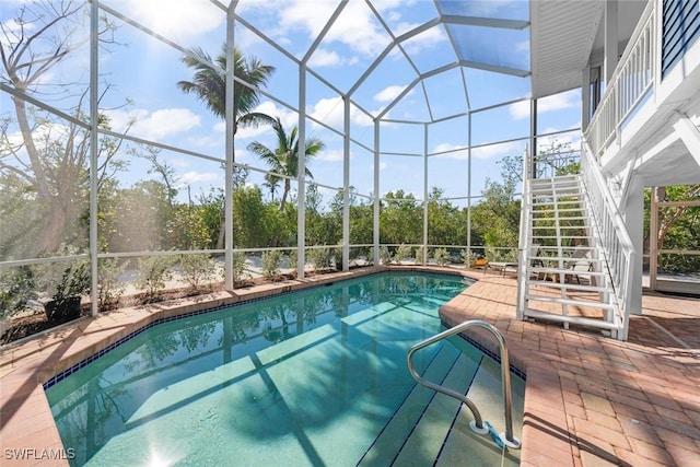 view of swimming pool with a patio and a lanai