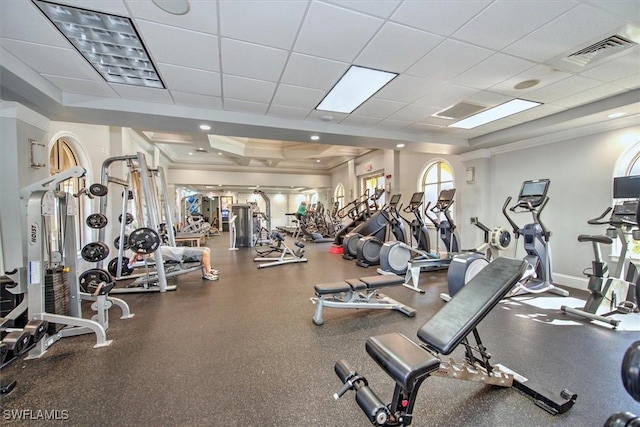 exercise room featuring ornamental molding, a paneled ceiling, and a tray ceiling