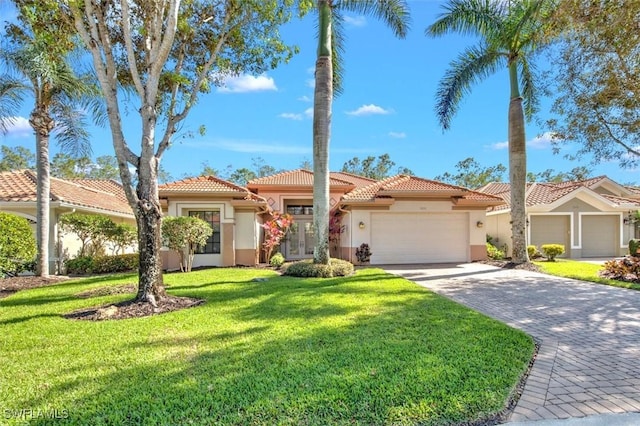 mediterranean / spanish house with a garage and a front yard