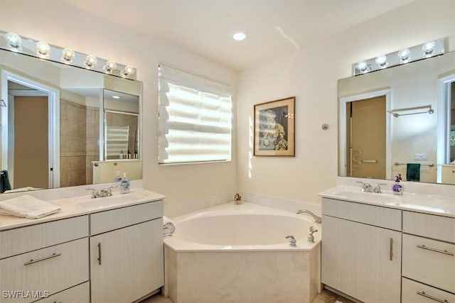 bathroom with vanity and shower with separate bathtub