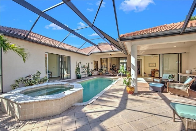 view of pool featuring a patio, glass enclosure, and an in ground hot tub