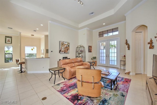 tiled living room with crown molding and french doors