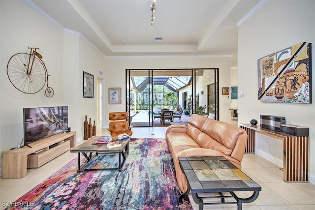 living room with crown molding, track lighting, a tray ceiling, and light tile patterned floors