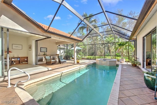 view of pool with an in ground hot tub, glass enclosure, and a patio