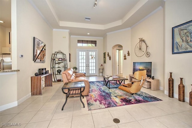 living room with french doors, a raised ceiling, and light tile patterned floors