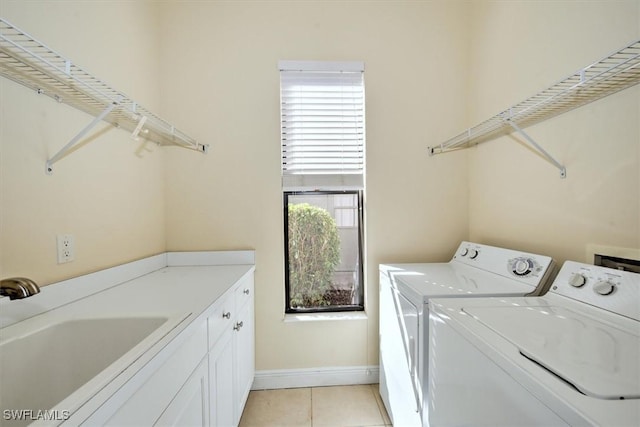 washroom featuring cabinets, sink, independent washer and dryer, and light tile patterned floors