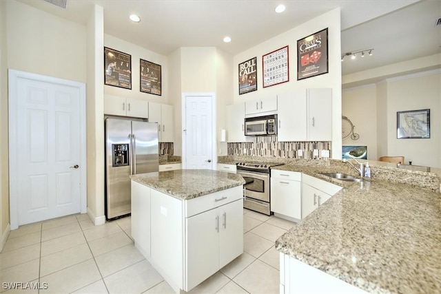 kitchen with light stone counters, appliances with stainless steel finishes, sink, and white cabinets