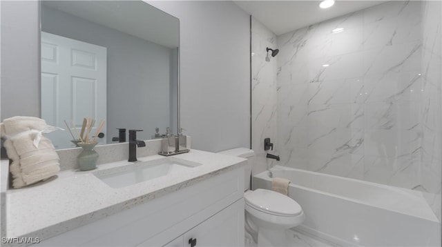 full bathroom featuring tiled shower / bath combo, vanity, and toilet