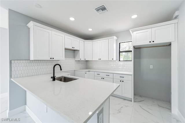 kitchen with sink, white cabinets, and kitchen peninsula