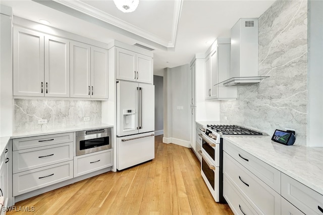 4931 Bonita Bay Blvd Unit 2103, Bonita Springs, FL 34134 - kitchen featuring white appliances, wall chimney exhaust hood, ornamental molding, light wood finished floors, and decorative backsplash