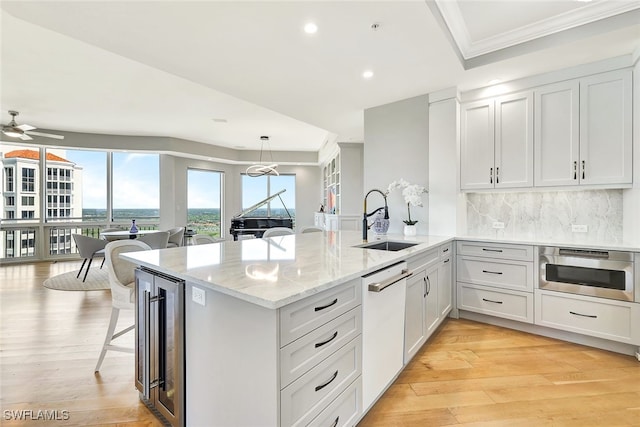 4931 Bonita Bay Blvd Unit 2103, Bonita Springs, FL 34134 - kitchen featuring a sink, white dishwasher, wine cooler, a peninsula, and decorative backsplash