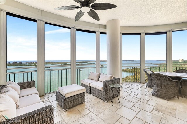 4931 Bonita Bay Blvd Unit 2103, Bonita Springs, FL 34134 - sunroom featuring a water view, stone tile floors, and a textured ceiling