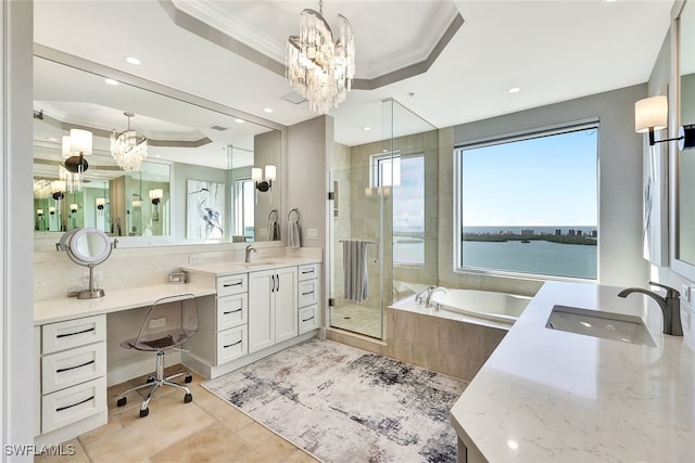 bathroom with independent shower and bath, a raised ceiling, a chandelier, and a water view