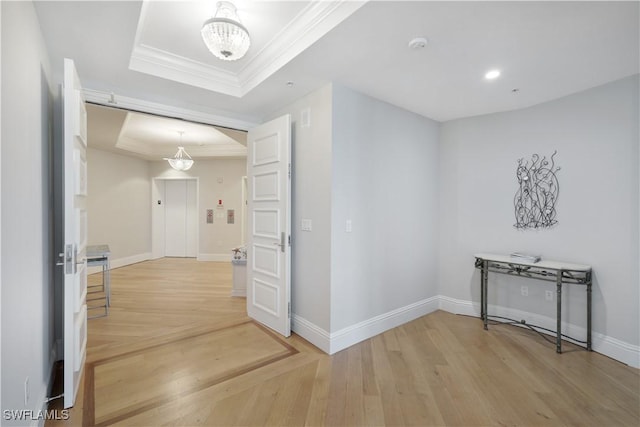 4931 Bonita Bay Blvd Unit 2103, Bonita Springs, FL 34134 - hallway featuring a raised ceiling, a chandelier, crown molding, light wood-style floors, and baseboards