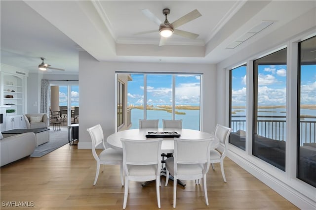 4931 Bonita Bay Blvd Unit 2103, Bonita Springs, FL 34134 - dining area featuring ceiling fan, a raised ceiling, a water view, crown molding, and light wood finished floors