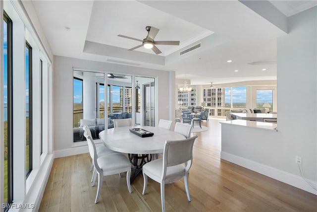 4931 Bonita Bay Blvd Unit 2103, Bonita Springs, FL 34134 - dining space featuring a raised ceiling, ceiling fan, baseboards, light wood-style floors, and a chandelier