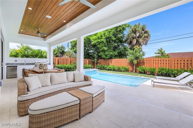 view of pool with an outdoor kitchen, ceiling fan, an outdoor hangout area, and a patio area