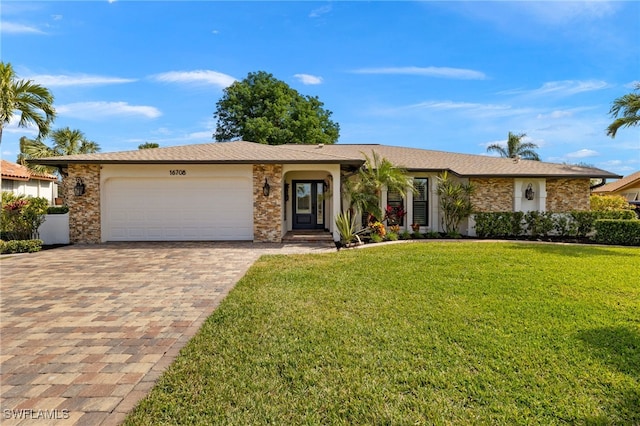 ranch-style house featuring a garage and a front lawn