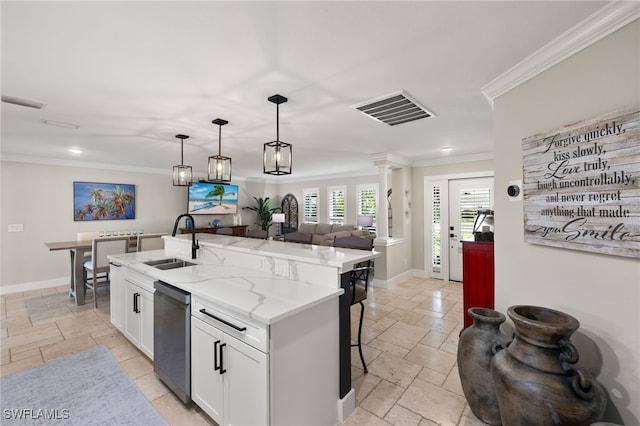 kitchen with sink, a kitchen island with sink, white cabinetry, light stone countertops, and decorative light fixtures