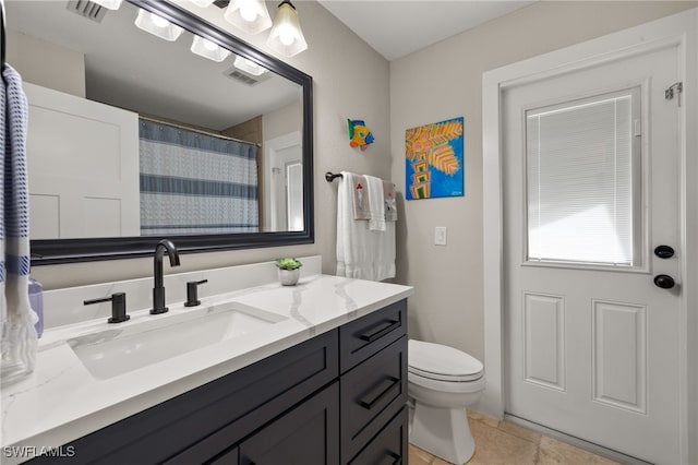 bathroom with vanity, tile patterned floors, and toilet