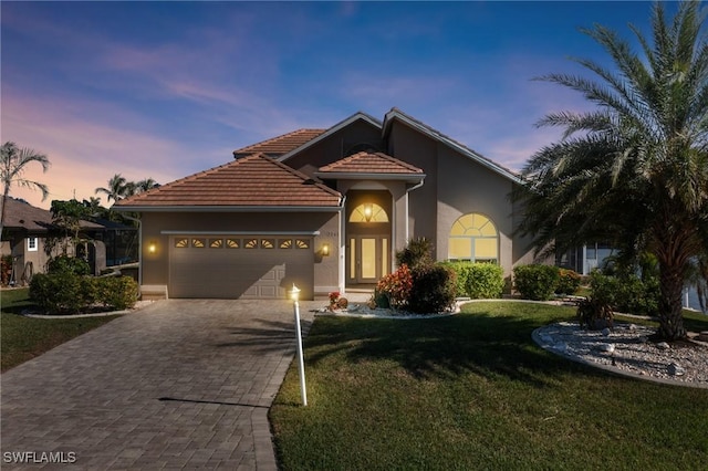 mediterranean / spanish-style home featuring a garage and a lawn