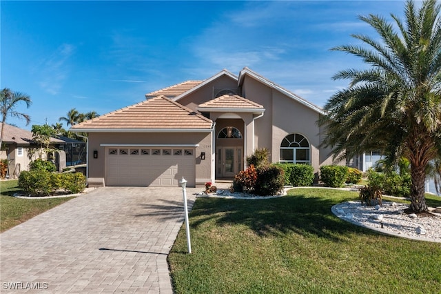 mediterranean / spanish-style home featuring a garage and a front yard