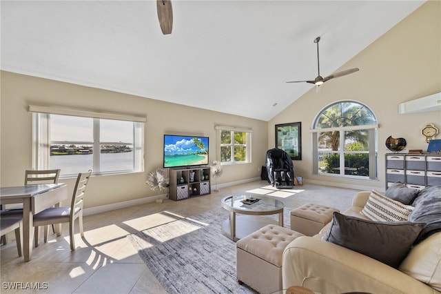 living room with vaulted ceiling, plenty of natural light, light tile patterned floors, and ceiling fan