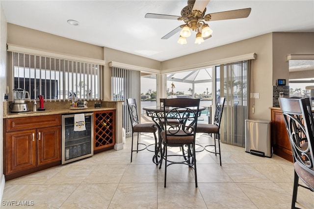 dining room featuring wine cooler, light tile patterned floors, and ceiling fan