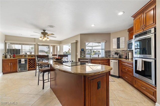 kitchen with sink, double oven, a center island, wine cooler, and black electric cooktop