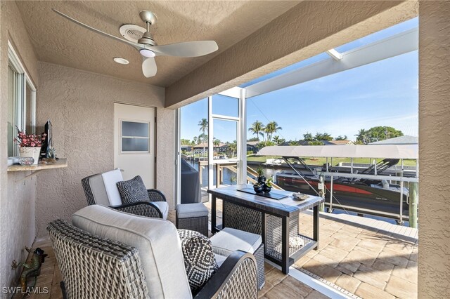 view of patio / terrace with ceiling fan and a water view