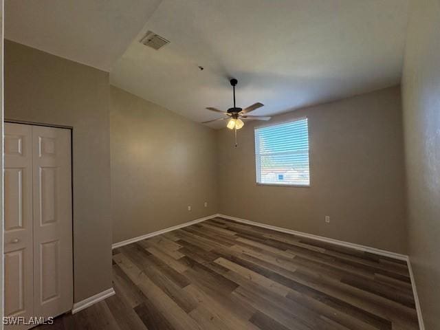 unfurnished room with dark wood-type flooring and ceiling fan