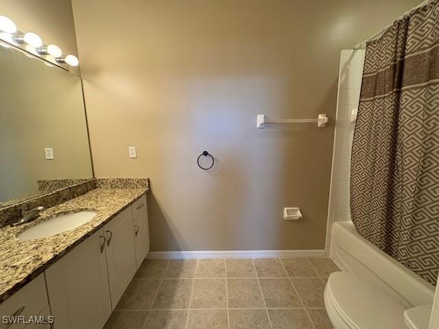 full bathroom with tile patterned flooring, toilet, vanity, and shower / bath combo with shower curtain