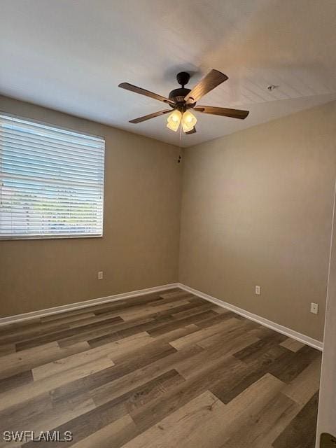 empty room with dark hardwood / wood-style floors and ceiling fan