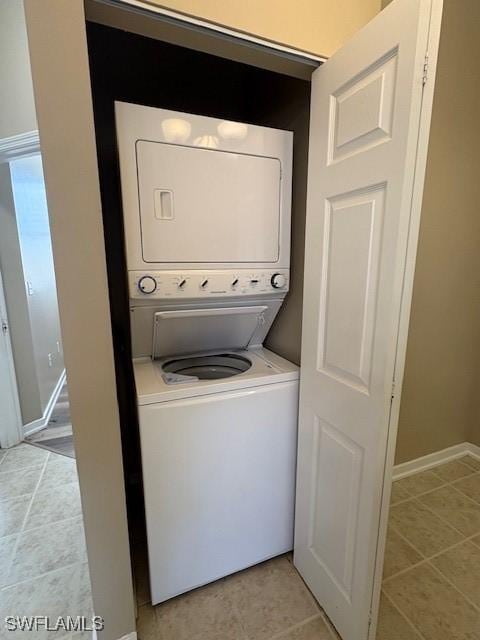 washroom featuring light tile patterned flooring and stacked washer / dryer