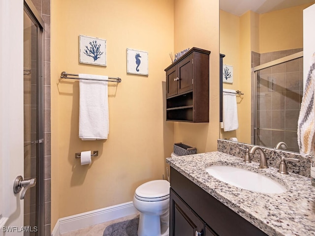 bathroom featuring vanity, a shower with door, and toilet